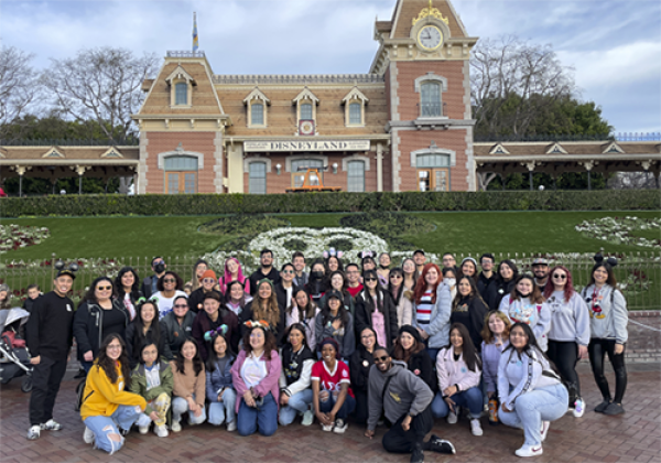 A large group of people in front of a building in Disneyland.