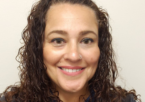 a person with curly hair who is smiling.