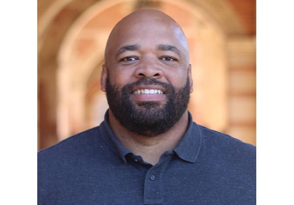 Professor Jackson smiling while wearing a dark polo