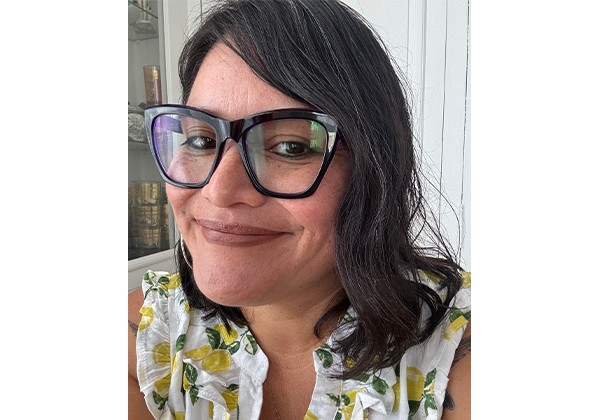 Karla Cativo wearing glasses and a white top with lemons on it