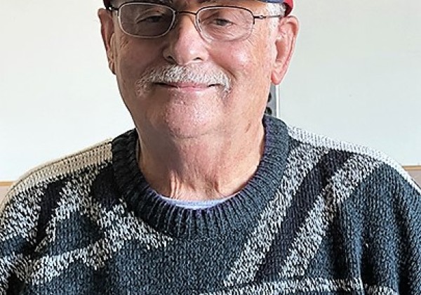 A man wearing a red cap smiling at the camera.