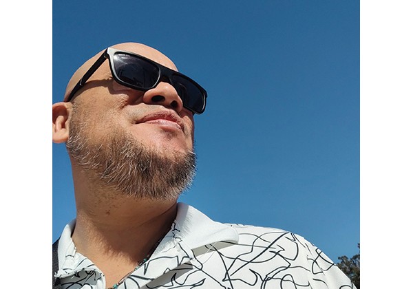 Richard wearing sunglasses with a white shirt outside