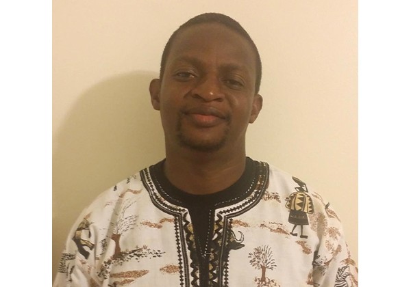 Tavengwa Gwekwere standing in front of beige wall