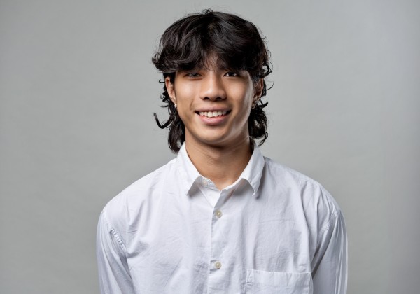 Portrait of Tzu Chen Hung, CREAR Futuros mentor, smiling in a white button-up shirt against a gray background.