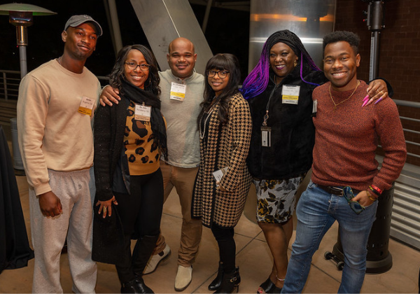 Six alumni posing with big smiles at the Black Alumni Network Mixer
