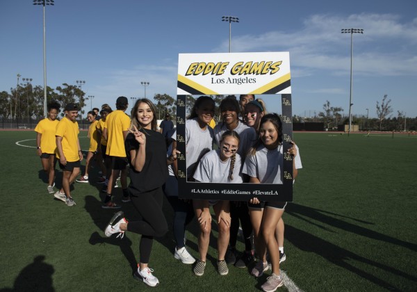 A group of students posing with a life-sized Eddie Games frame.