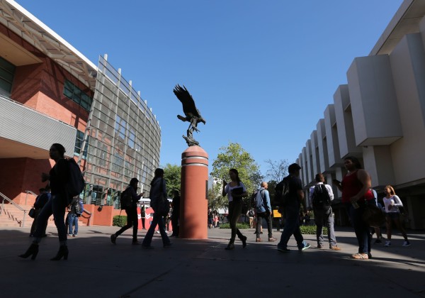 statue of golden eagle and student walking around