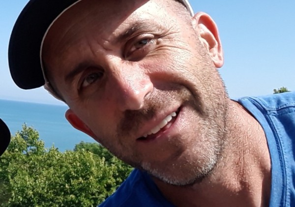A mean wearing a cap with the sun reflected on his face.