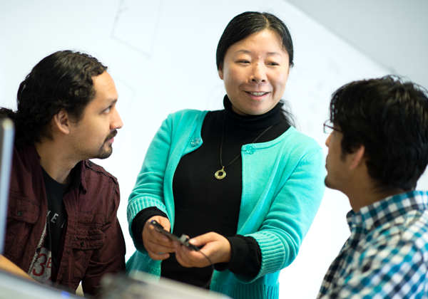 female faculty explains electronic to male students