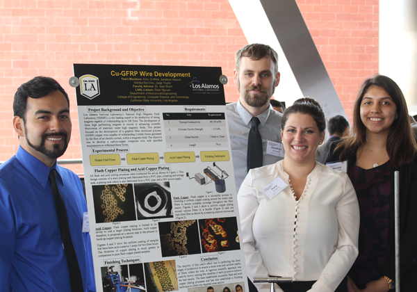 capstone student team stand with project poster at expo