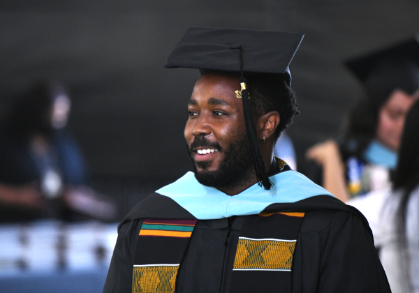 Male graduate wearing cap and gown.