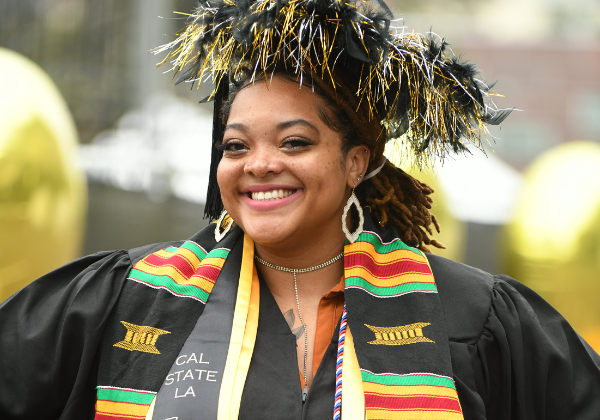 Female graduate in festive cap and gown.