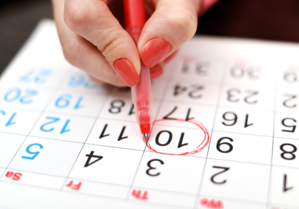 Hand circling a date on a calendar