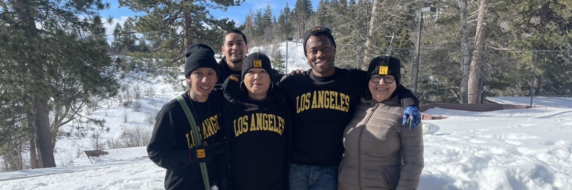 Five people standing outside in the snow.