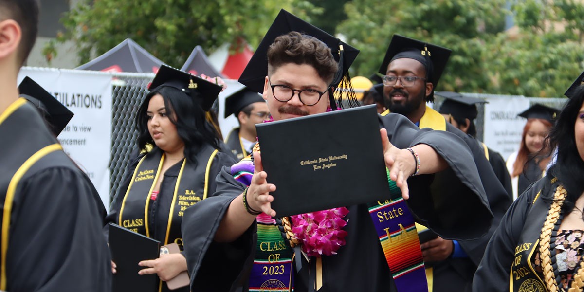 Student with DIploma leaving commencement