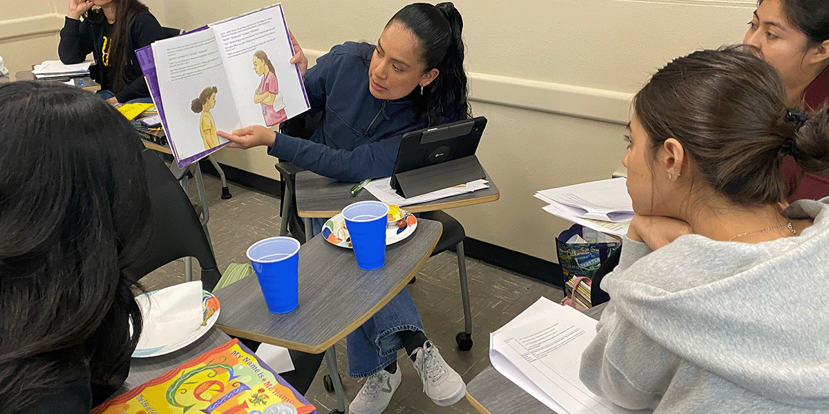Student reading picture book in a small group of students