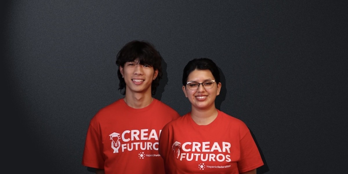 From left to right: Two CREAR Futuros mentors wearing red program T-shirts smile in front of a neutral background. Tzu Chen Hung and Sam Aguilar.