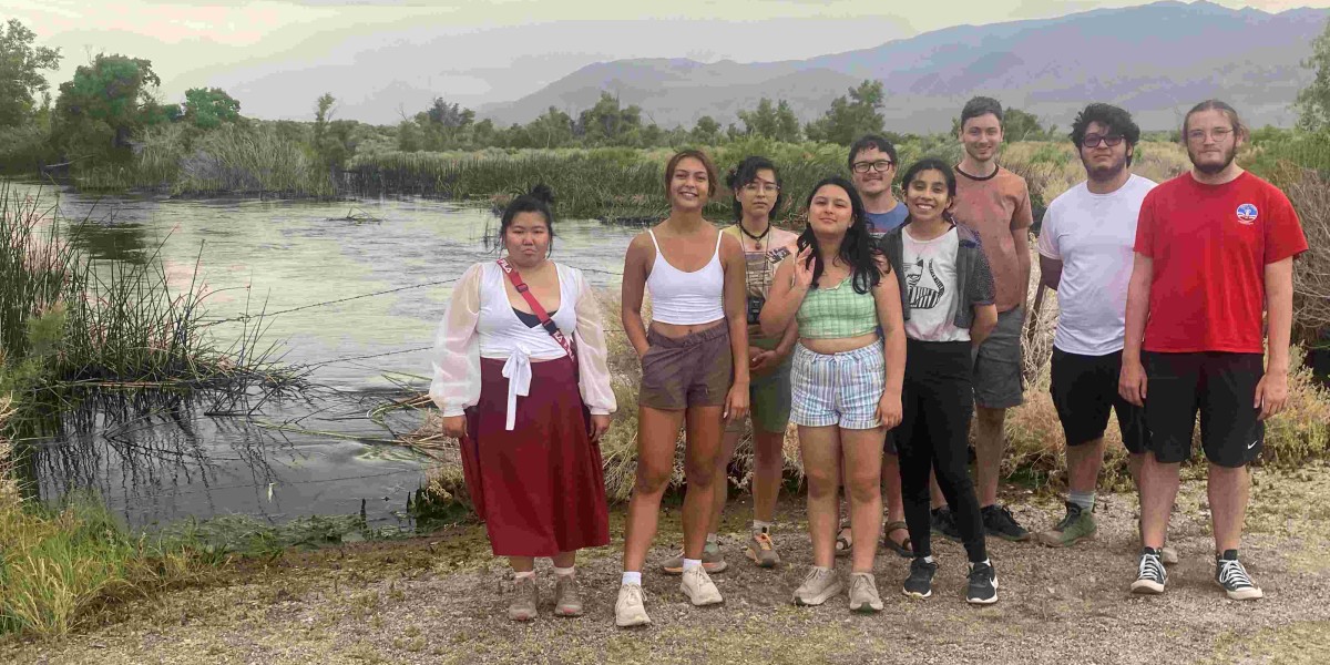 A group of students standing infront of the lagoon. 