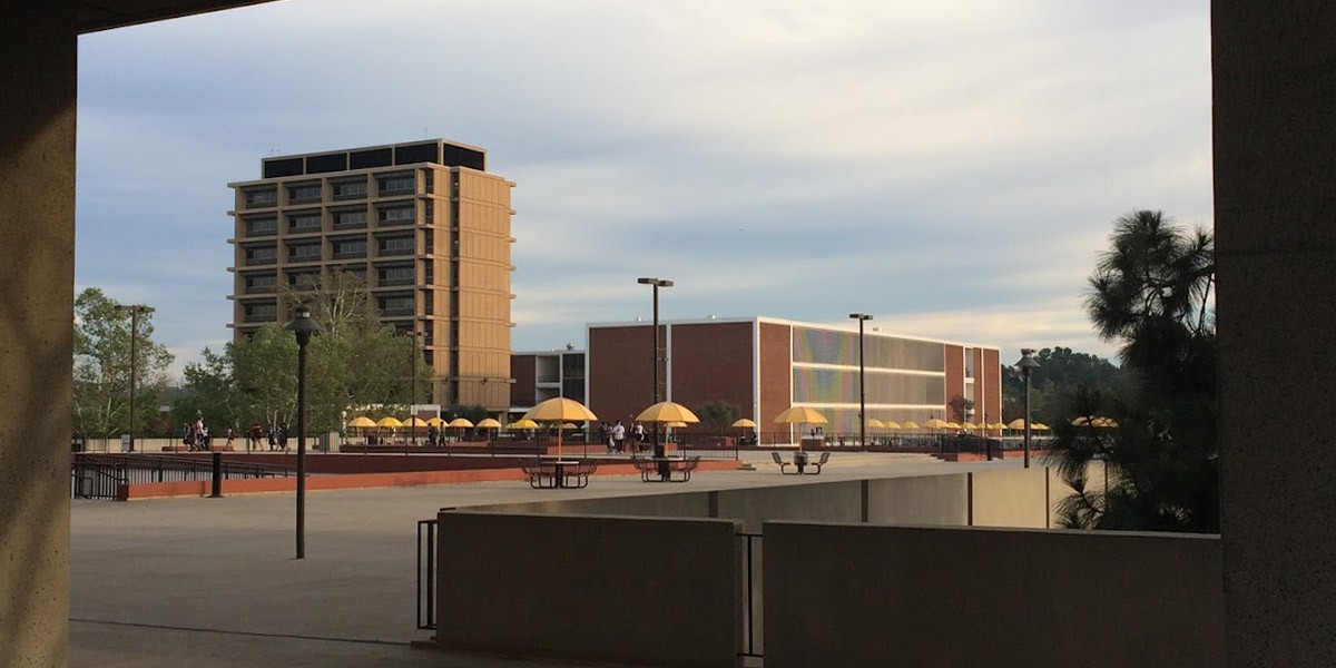 A wide angle view of a plaza with buildings and trees.