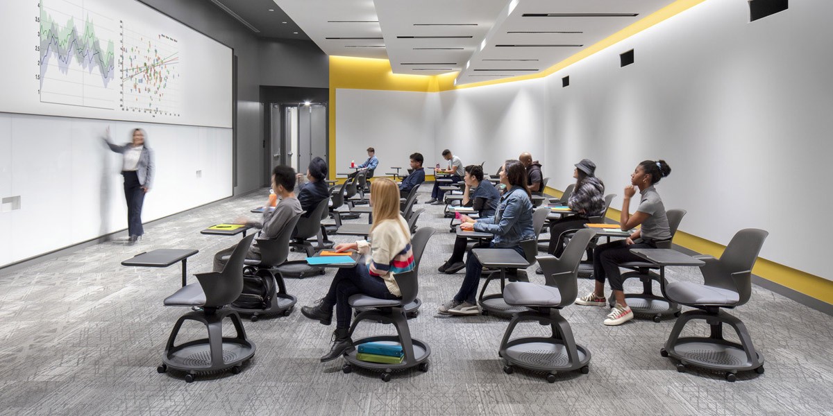 A modern lecture hall with a professor giving a lecture to a room full of students.