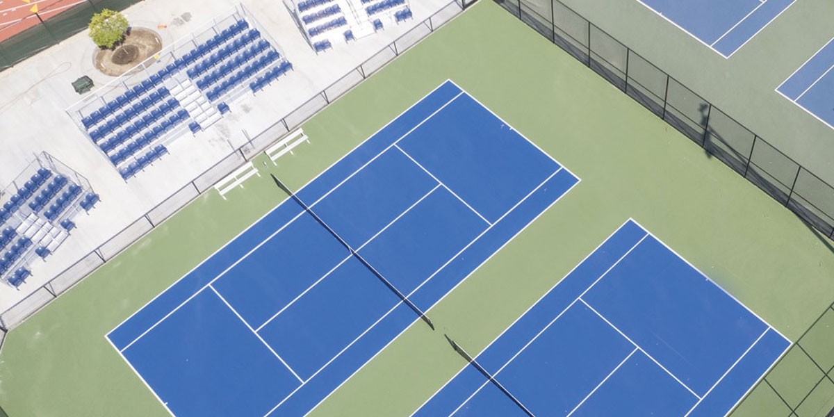 An aerial view of tennis courts on a sunny day.
