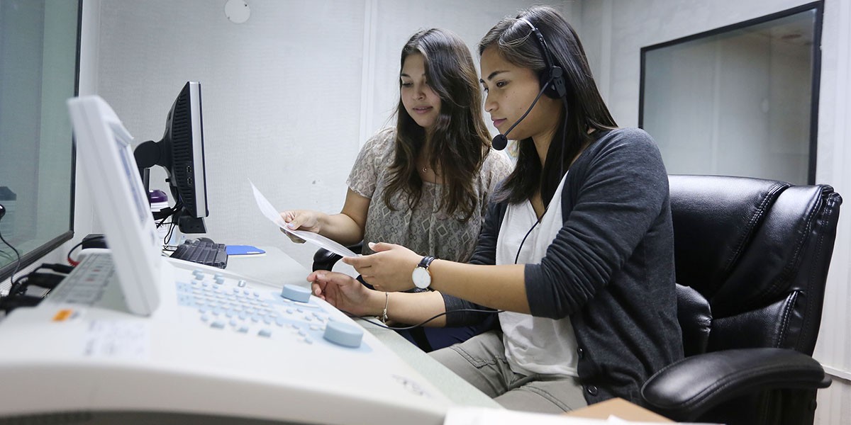 two students in front of hearing assessment machine