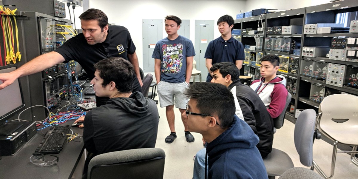 faculty and students work with electronics in lab