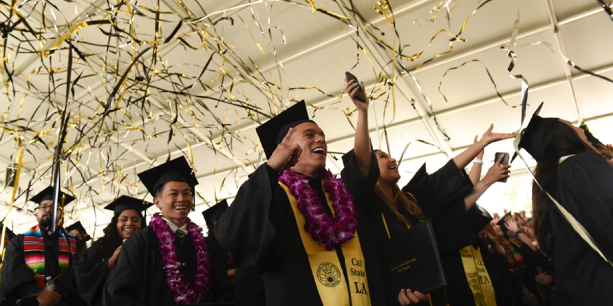 Graduates celebrating under confetti streamers.