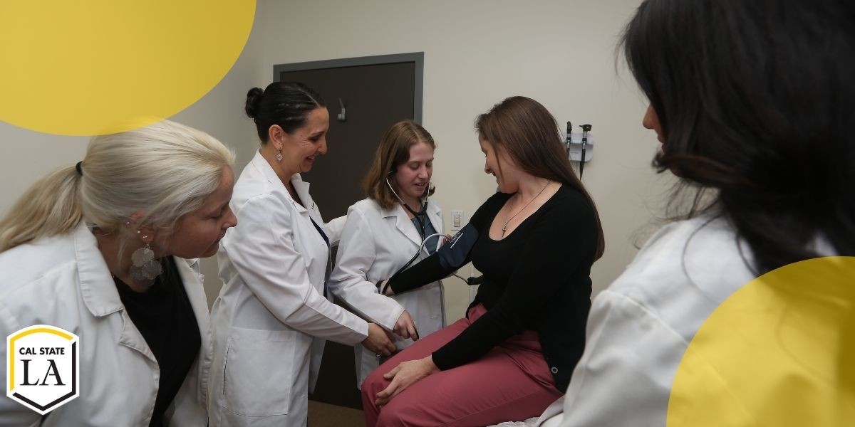 Four health professions students in white coats examining female patient