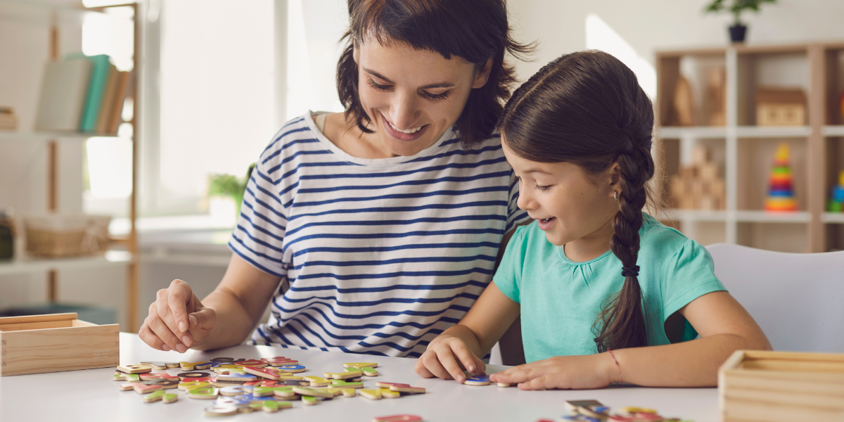 Women and child work on a puzzle together.