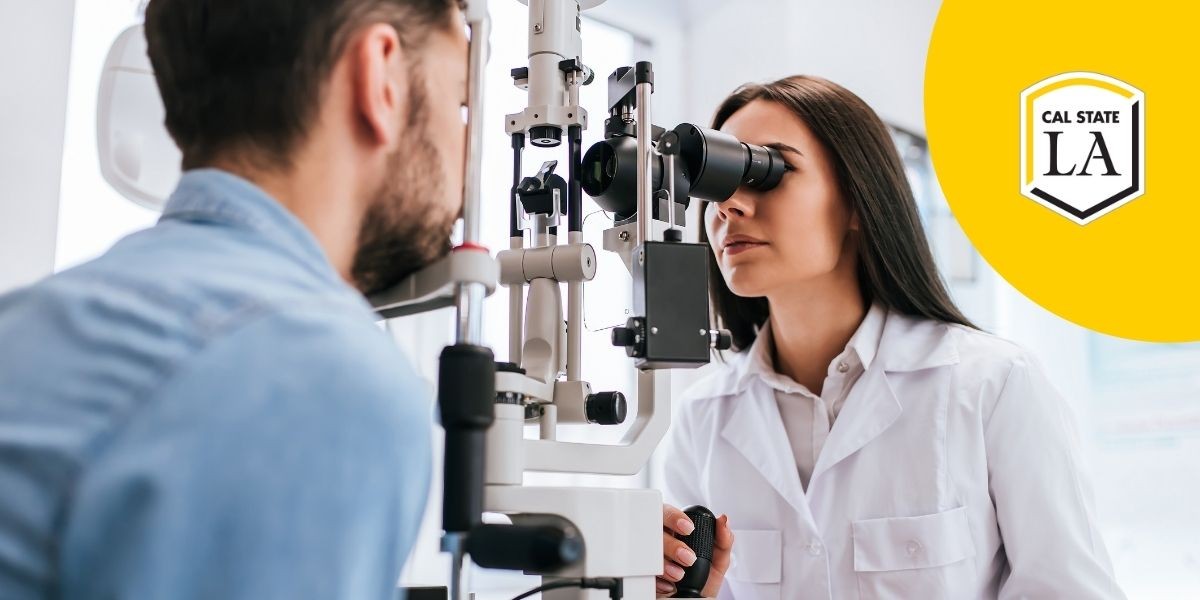 Female eye doctor in white coat examining male patient's eye through a machine 