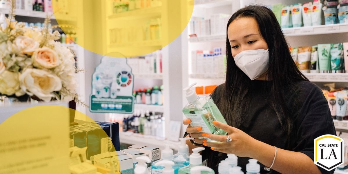 Young woman looking at hand sanitizer. She is in a pharmacy room with prescription medcation