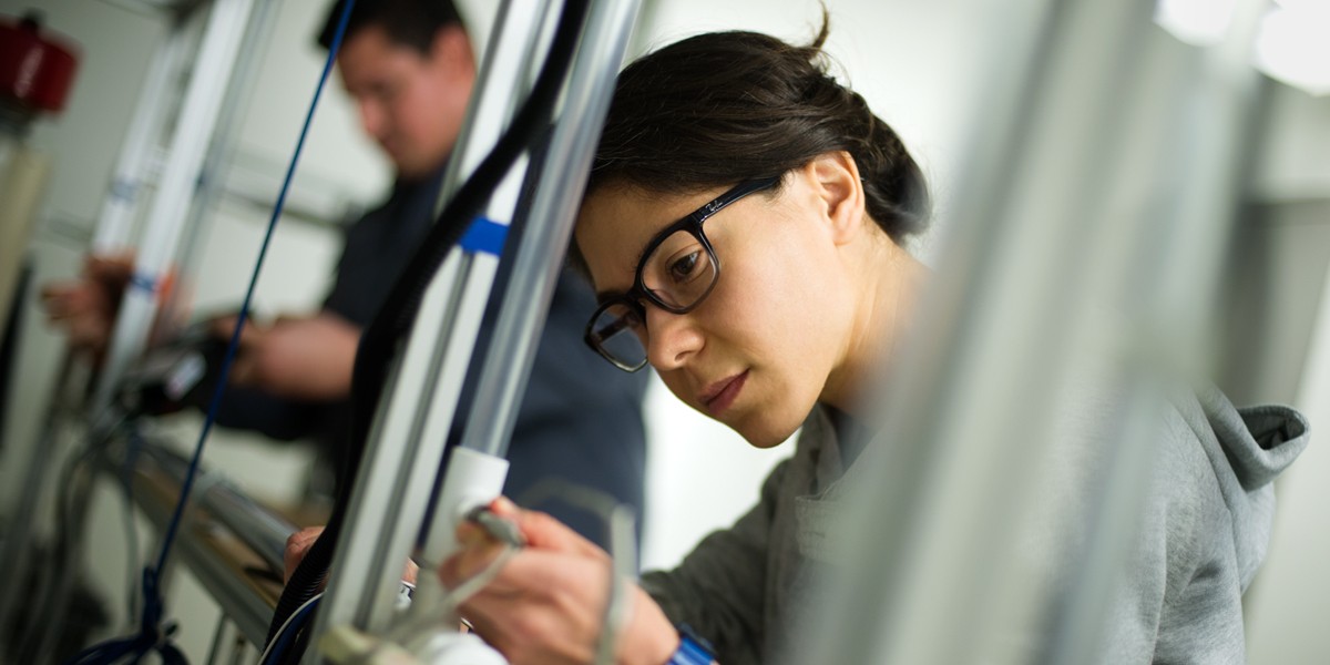 student using instrument on project in lab