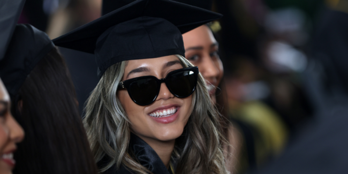 Female graduate wearing cap, gown and sunglasses.