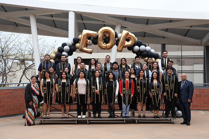 Group of students wearing graduation sashes.