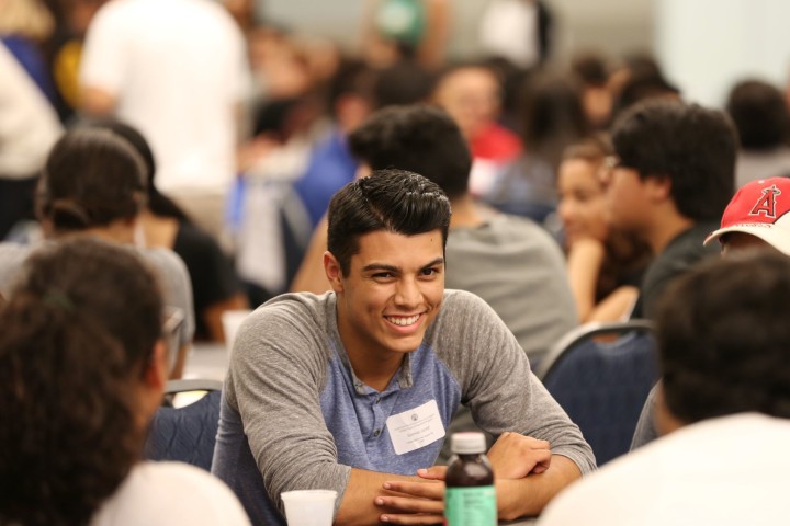 Student with name tag smiling at other students