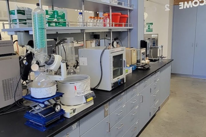 Synthesis lab bench with rotavap, oven and balance.