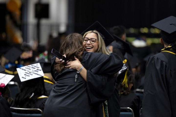 student hugging a loved one at a graduation ceremony