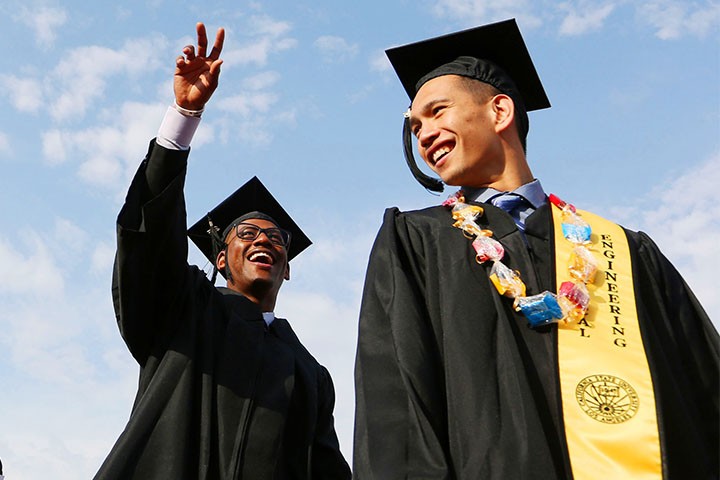 two graduates walking towards commencement