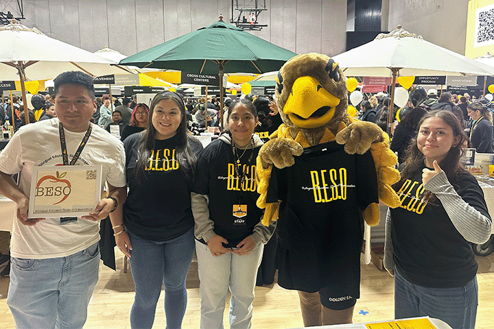 Students wearing BESO shirts standing with Eddie the GOlden Eagle