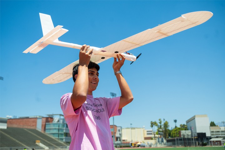 C3DPAC 2026 student in pink t-shirt hold UAV above head
