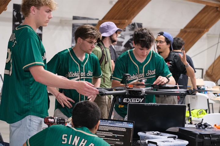 students wearing green work on UAV during 2026 competition