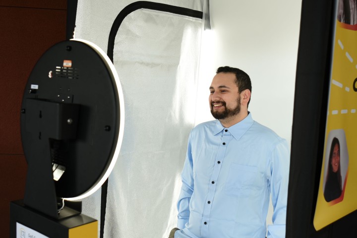Student smiles confidently while taking professional photo in the Career Photo Booth