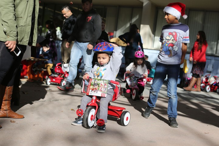 A small child on a tricycle.