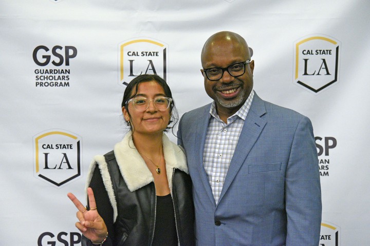 Two people standing, smiling.