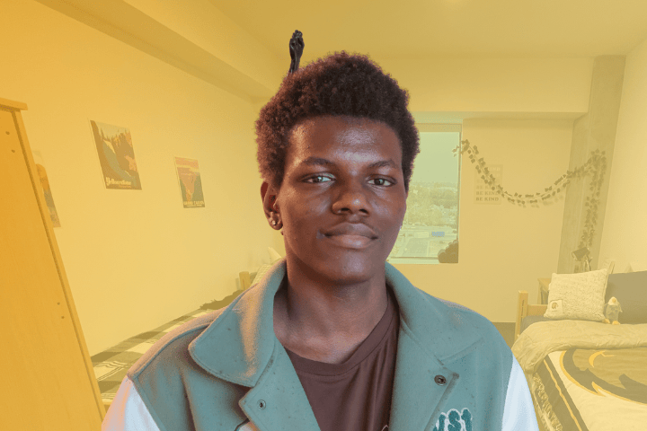 Cal State LA resident smiling in front of Housing.