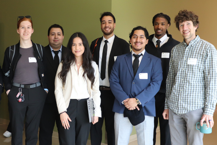students stand staggered in front of hues of green and yellow