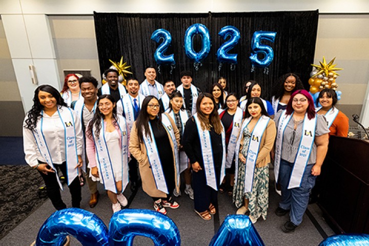 A group of students wearing graduation sashes.
