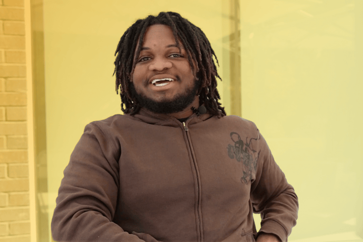 Cal State LA resident smiling in front of South Village.