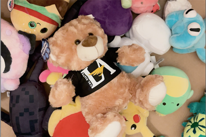 A stuffed teddy bear in a box of toys.